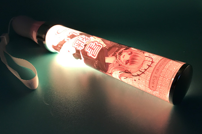 黒いドレスと笑顔が光るスティック型ペンライト