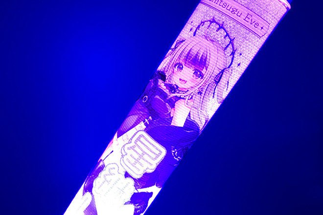 黒いドレスと笑顔が光るスティック型ペンライト