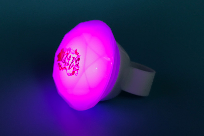 草花に囲まれた文字がきらめくダイヤ型リングライト